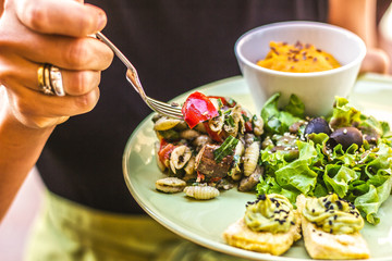 Piatto vegano con insalata di pasta al pesto e insalata