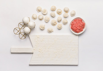 Preparing of tasty dumplings on white background