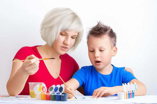 Pretty young girl teaches drawing a cute boy. Mom and son painting together. Education, personal lessons, leisure, family activities during quarantine concept