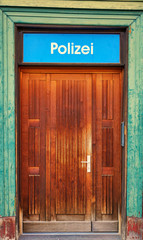 Police station sign as text in German letters over an old door.