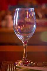 Empty wine glass. Tableware on table in cafe, focus on wineglass stem . Elegant table setting . Bakal