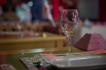 Empty wine glass. Tableware on table in cafe, focus on wineglass stem . Elegant table setting . Bakal