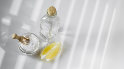 Vinegar, baking soda and lemon on white background