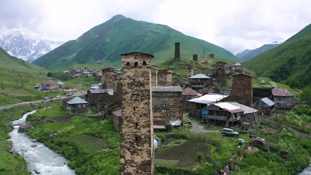 Ancient stone towers and Ushguli village at the foot of Mt. Shkhara. Picturesque and gorgeous scene. Rock tower towers and old houses in Ushguli.