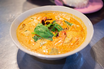 A bowl of hot and spicy tom yum kung on table, Thai street food