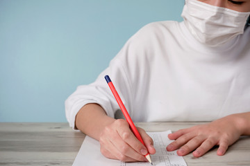 Woman wearing a mask and taking an exam.  マスクを着用して試験を受ける女性
