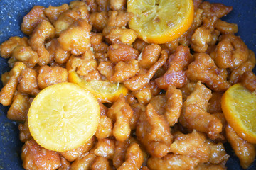 Chicken meat cut into small pieces and wrapped in egg flour mixture. Put into the hot pan. It is fried using hot cooking oil until cooked and crunchy. Added with orange as a seasoning.