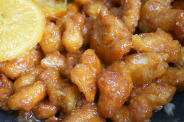 Chicken meat cut into small pieces and wrapped in egg flour mixture. Put into the hot pan. It is fried using hot cooking oil until cooked and crunchy. Added with orange as a seasoning.