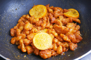Chicken meat cut into small pieces and wrapped in egg flour mixture. Put into the hot pan. It is fried using hot cooking oil until cooked and crunchy. Added with orange as a seasoning.