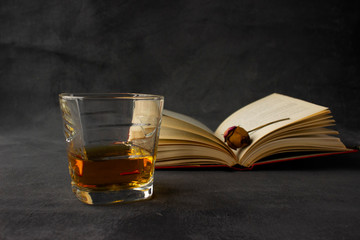 glass of whiskey and books