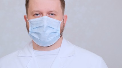 sad and upset Male in a protective mask and a white shirt looks at the camera, close-up. Hygiene concept. prevent the spread of germs and bacteria and avoid infection with the crown virus. copy space