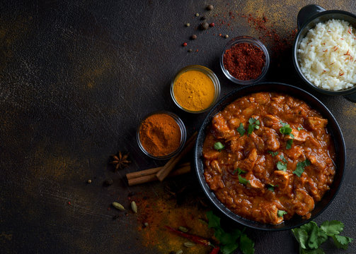 chicken curry with spices on a dark background