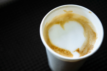 Barista draws milk over a coffee - making latte art for cappuccino