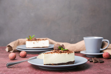 Plate with piece of chocolate cheesecake on table