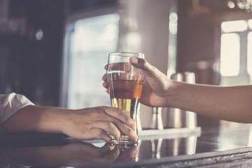 bartender serving beer for customer in counter at nightclub