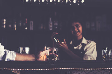 Beautiful girls bartender mix drinks and serve them to customers