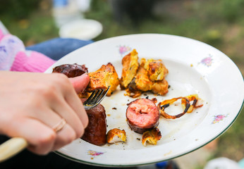 People eating grilled vegetables and meat. Sweet pepper and tomatoes. Good in village. Rustic style.