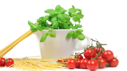 closeup of cherry tomatoes, spaghetti and basil jar on a white background	
