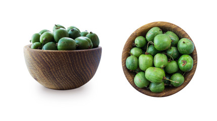 Green baby kiwi fruit actinidia isolated on white background. Actinidia in a bowl with copy space for text. Kiwi fruit actinidia. Top view. Actinidia from different angles isolated on white background