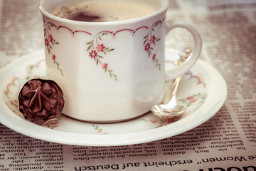 Kaffeepause mit Zeitung und Schokolade