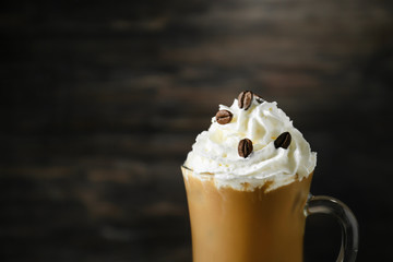 Glass cup of tasty iced coffee on dark background