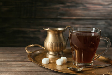Glass cup of tasty iced coffee with sugar on wooden background
