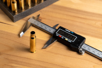 Production of cartridges for a rifle, reload. Measurement of the empty cartridges with a caliper. Side view