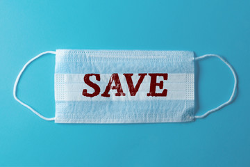 White medical mask with the inscription Save, blue background