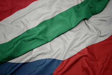 waving colorful flag of czech republic and national flag of hungary.