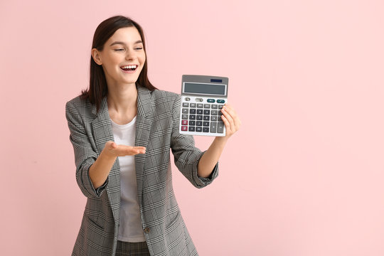 Young woman with calculator on color background