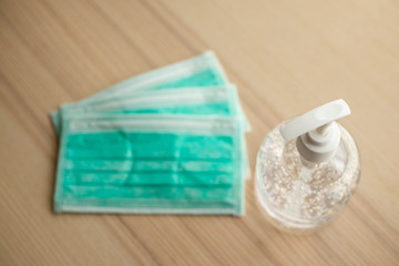 Medical face mask with alcohol sanitizer gel hand wash on wood table for covid-19 Coronavirus prevention concept