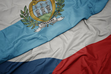 waving colorful flag of czech republic and national flag of san marino.