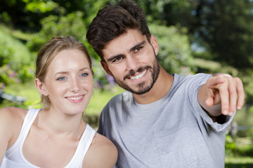 smiling couple pointing away on white background