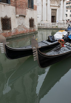 Detail of Venetian gondola in green canal waters of Venice Italy