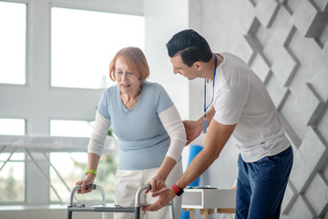 Nice aged woman trying to walk with medical assistance