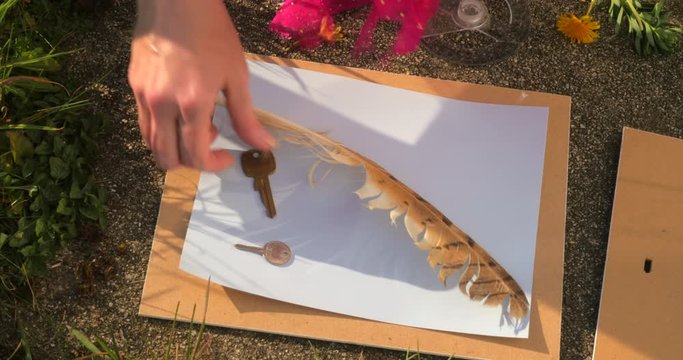Feather and keys laid on photographic paper for photogram, high angle