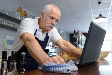 a senior barman using computer