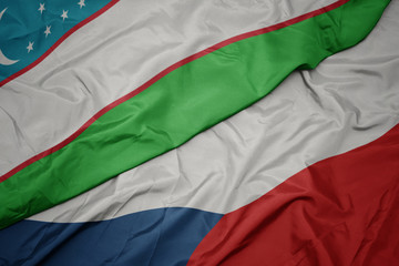 Fototapeta premium waving colorful flag of czech republic and national flag of uzbekistan.