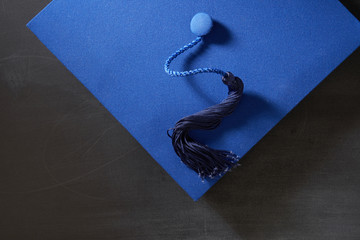 Graduation hat, diploma scroll on the blackboard