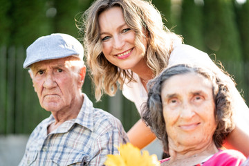 Middle Age woman with senior parents in park