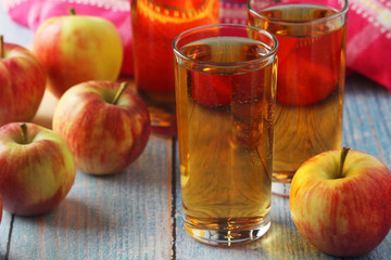 Glasses with apple juice and ripe apples