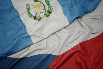 waving colorful flag of czech republic and national flag of guatemala.