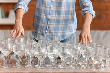 Young woman playing music on glasses with water at home