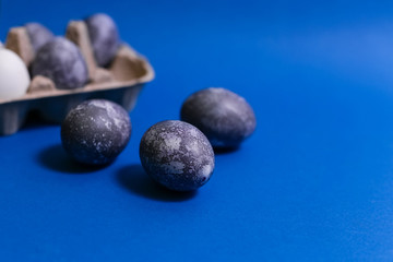Eggs with marble stone effect painted with natural dye carcade flower on blue sparkling background