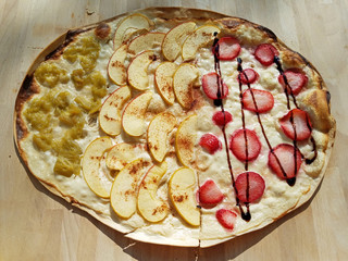 Ein leckerer Flammkuchen belegt mit Früchten, Erdbeeren, Äpfeln und Rhabarber
