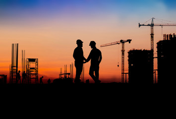 Fototapeta na wymiar Silhouette Engineer and construction team working at site over blurred industry background with Light fair Film Grain effect.Create from multiple reference images together