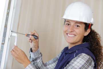 woman installing door handle using screwdriver