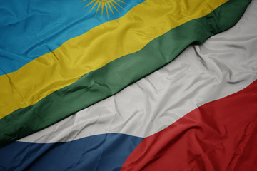 waving colorful flag of czech republic and national flag of rwanda.