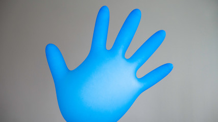Inflatable blue rubber glove on a gray background.