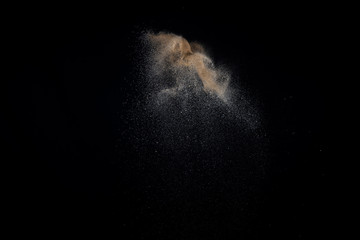 Sandy explosion isolated on black background. Abstract particles cloud. Texture element for design.